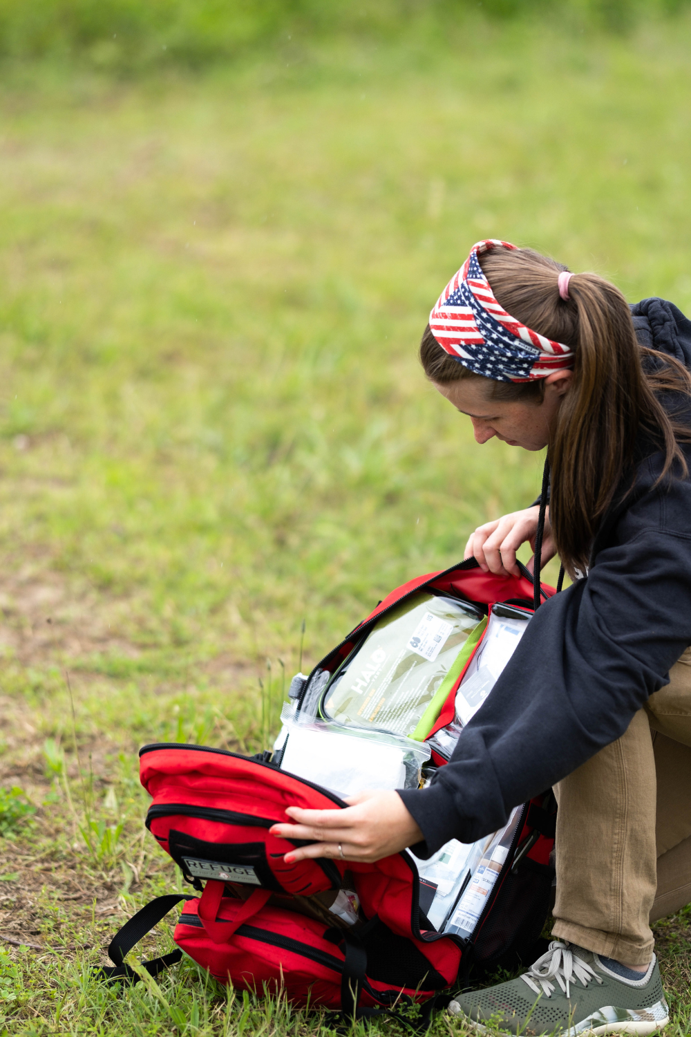 Refuge Medical Field Medic First Aid Backpack - Red, person opening backpack