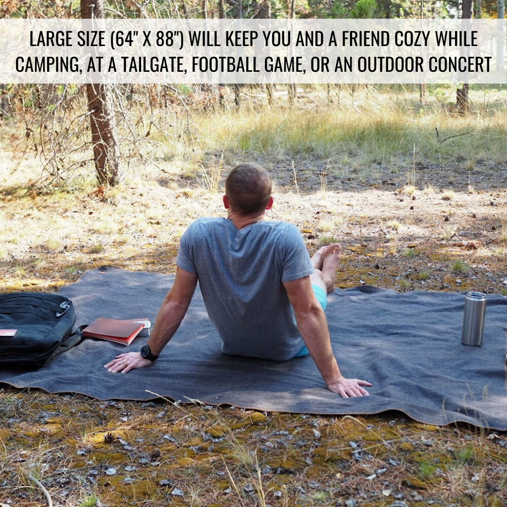 Person sitting on laid out Arcturus wool blanket with text at the top of the image (Large size 64"x88")