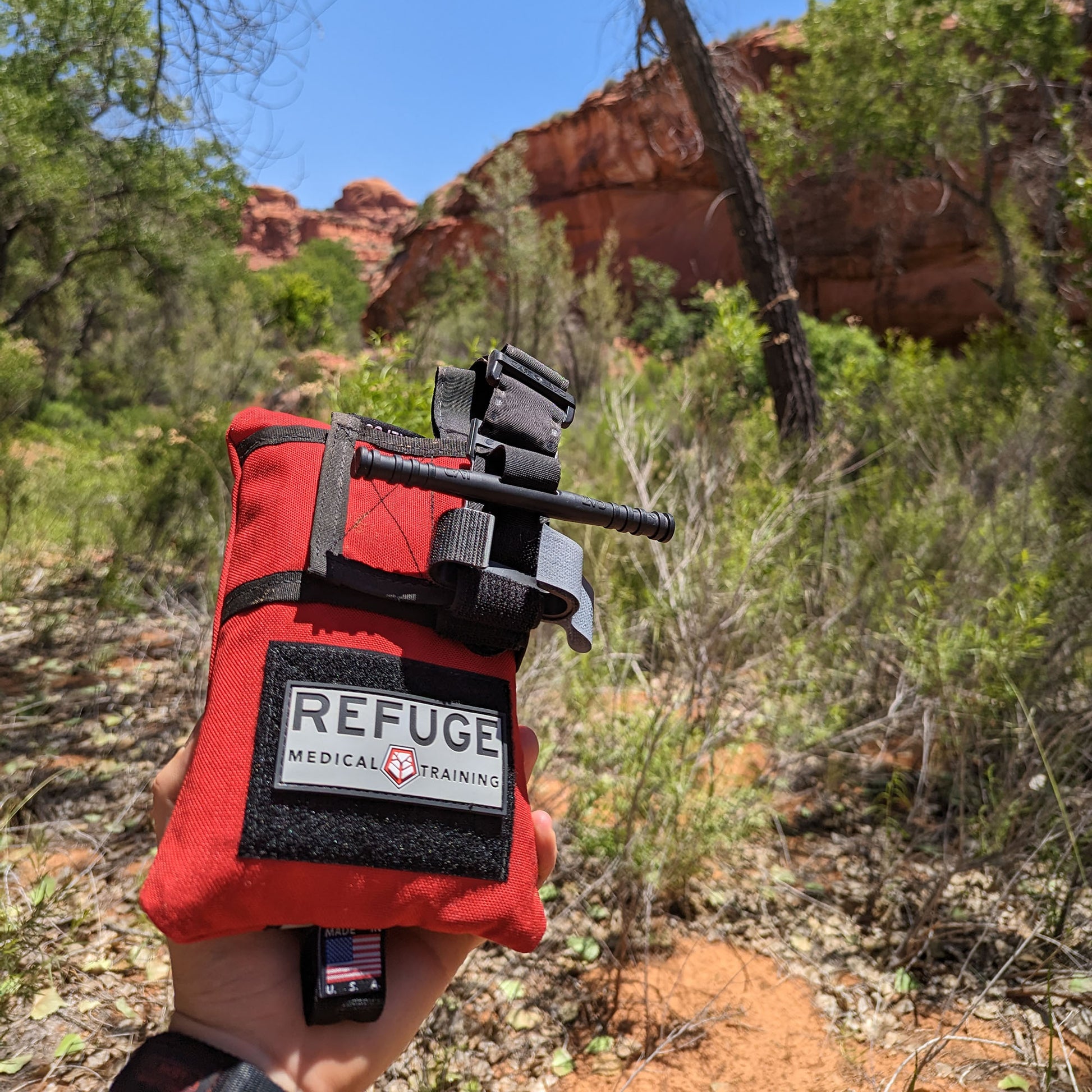 Refuge Medical Boo Boo First Aid Kit - person holding Boo Boo Kit in front of trees